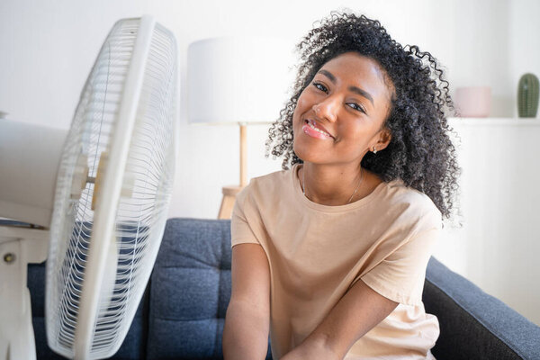 Черная женщина дома освежает во время летнего тумана улыбаясь