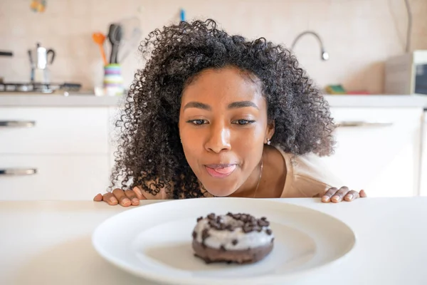 Sad back woman dieting trying to avoid junk food snacking