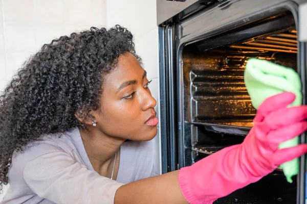 Una Mujer Negra Haciendo Tareas Domésticas Horno Limpieza —  Fotos de Stock