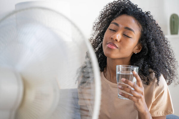 Черная женщина дома освежает во время летнего тумана
