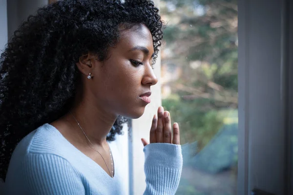窓の前で一人の黒人女性が祈る — ストック写真