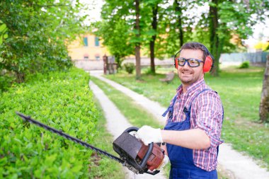 Çim biçme makinesi kullanan bir bahçıvan.