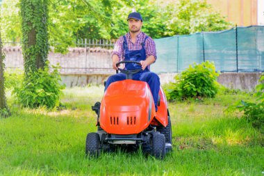 Professional lawn mower worker cutting grass in home garden