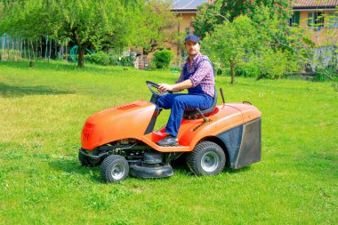 One gardener driving riding lawn mower garden