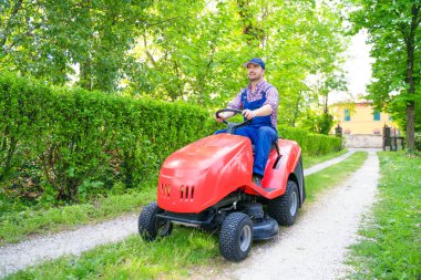 One gardener driving riding lawn mower garden