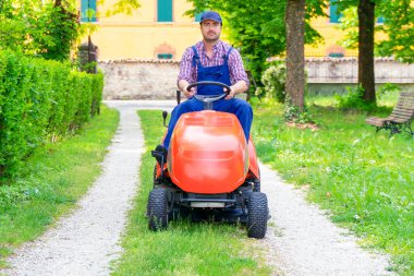 Professional lawn mower worker cutting grass in home garden