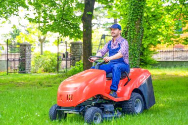 Professional lawn mower worker cutting grass in home garden