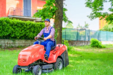 One gardener driving riding lawn mower garden
