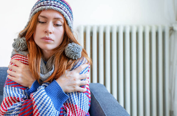 Один человек чувствует себя холодно дома с проблемой отопления