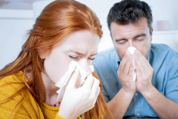 Couple suffering cold and flu and sneezing nose