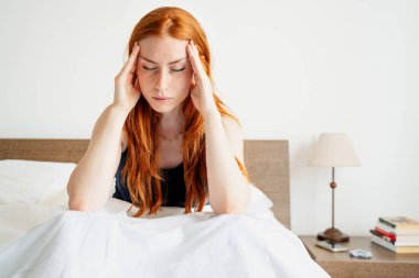 Tired woman lying awake in bed suffer from insomnia headache