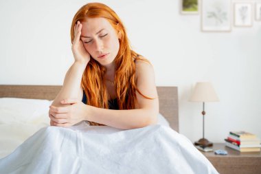 Tired woman lying awake in bed suffer from insomnia headache
