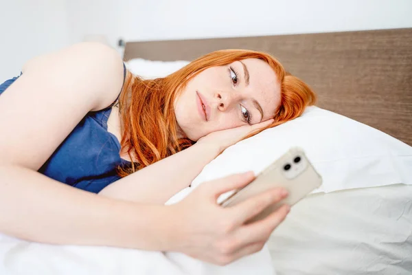Женщина Держит Мобильный Телефон Лежит Кровати — стоковое фото