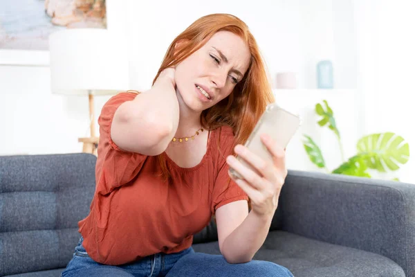 Mujer Sentada Sofá Sosteniendo Teléfono Sufre Dolor Cuello — Foto de Stock