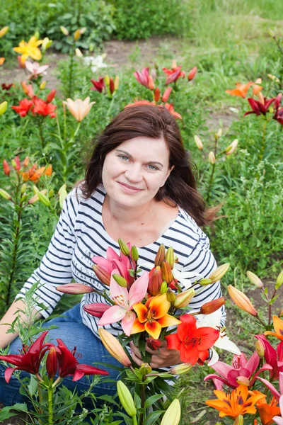 Jeune belle femme avec bouquet de lis dans les mains — Photo