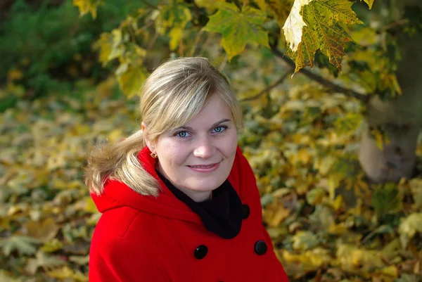 Žena v červeném kabátě v podzimní krajině — Stock fotografie