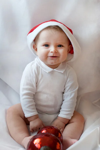 Adorable baby boy in Christmas cap and with ball — Stock Photo, Image