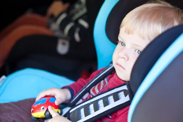 Adorable toddler with blue eyes in safety car seat — Stock Photo, Image