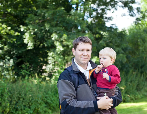 Ung man och bedårande pojke i sommar skog — Stockfoto