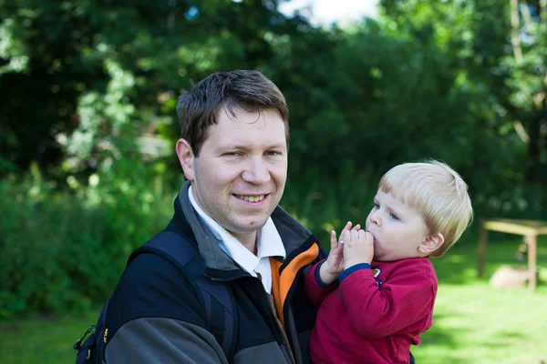 Unga far och hans barn pojke i sommar skog — Stockfoto