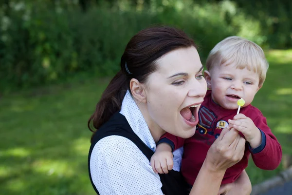 Giovane madre e adorabile bambino che gioca con lecca-lecca estate — Foto Stock