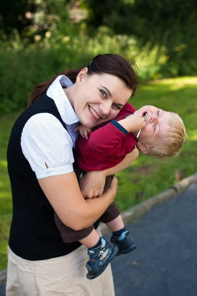 Joven madre y adorable niño jugando con piruleta verano —  Fotos de Stock