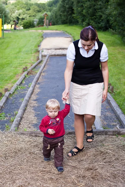 Young mother and toddler walking through nature park — Stock Photo, Image