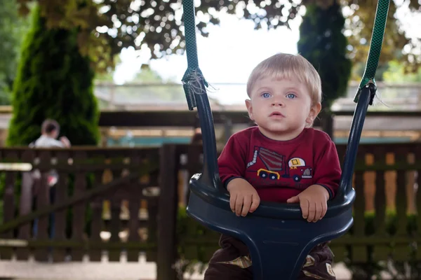 Schattige baby jongen peuter op Speeltuin schommel zomer — Stockfoto