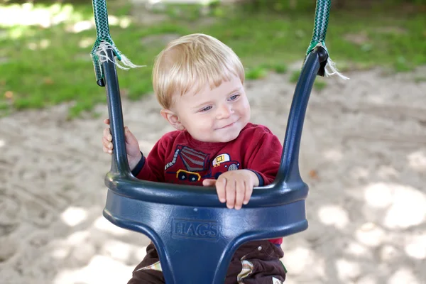 Lovely toddler on playground swing summer — Stock Photo, Image