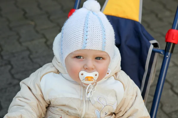 Schattige babyjongen in warme kleren op driewieler — Stockfoto