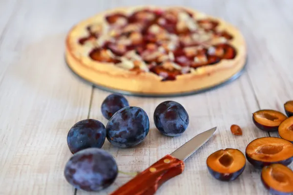 Torta di prugne appena sfornate con prugne fresche con focus su prugne e coltello — Foto Stock