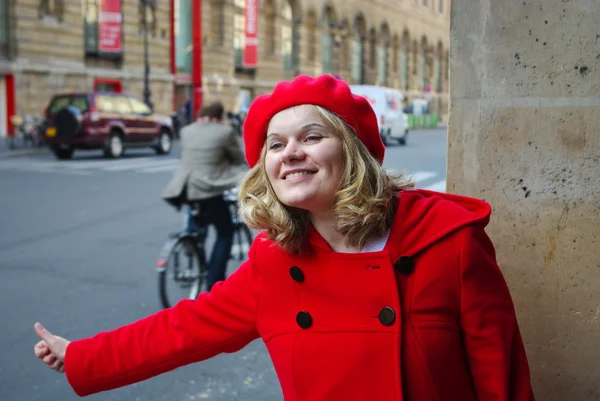 Kaunis nuori nainen punaisessa takissa odottaa taksi — kuvapankkivalokuva