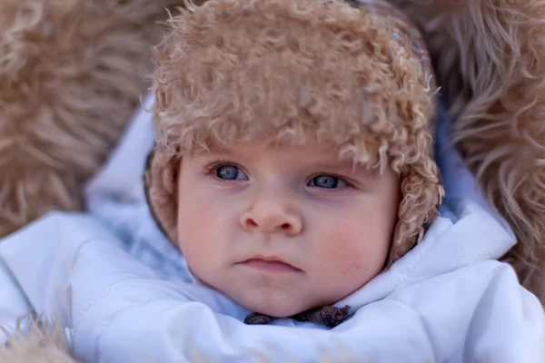 Little baby boy in pram in winter clothes with snowfall — Stock Photo, Image