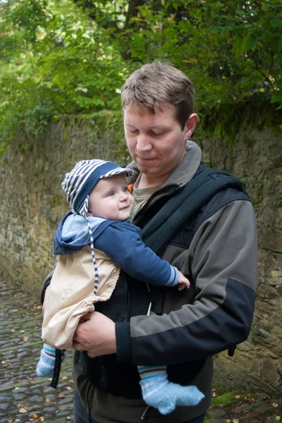 Unga far och hans son i ryggsäck i höst park — Stockfoto
