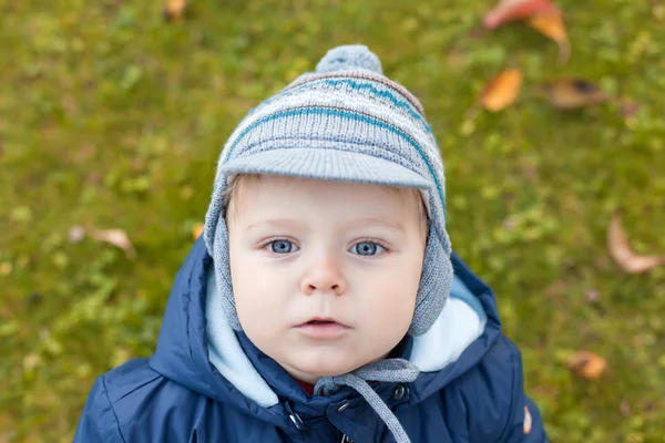 Söt härlig småbarn i höst trädgård i varma kläder — Stockfoto