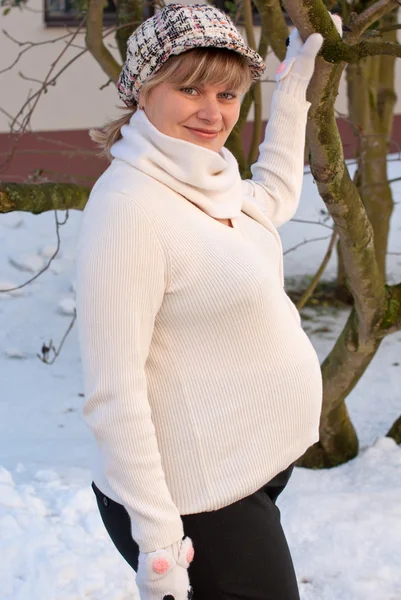 Vacker ung gravid kvinna i snö trädgård — Stockfoto