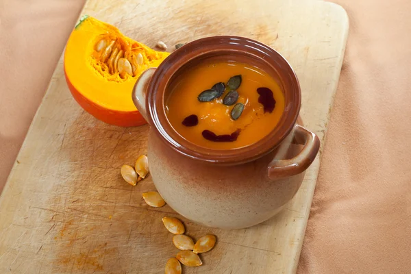 Zuppa di crema vegetale di zucca in ciotola marrone con zucca piese — Foto Stock