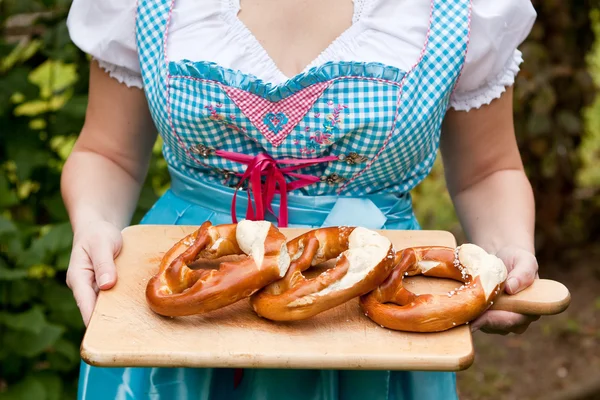 Happy krásná žena v šatech dirndl držel Oktoberfestu pretz — Stock fotografie