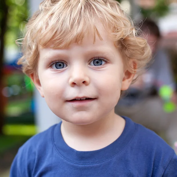 Sarı tüyleri olan küçük yürümeye başlayan çocuk portresi