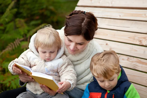 Young mother and toddler reading book outdoor — Stock Photo, Image