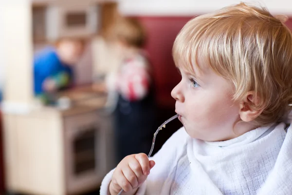 Bonito menino comendo ovo no café — Fotografia de Stock