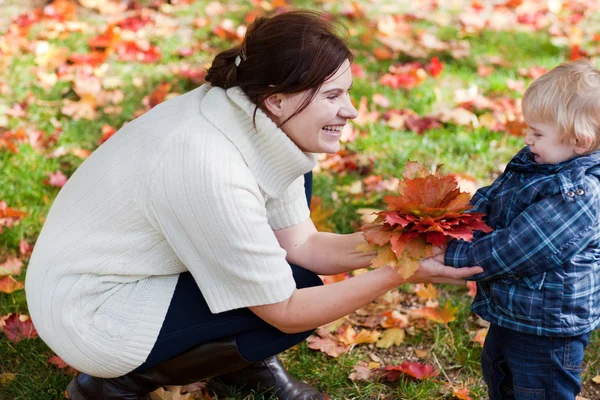 Lilla barn pojke och ung mamma i höst park — Stockfoto