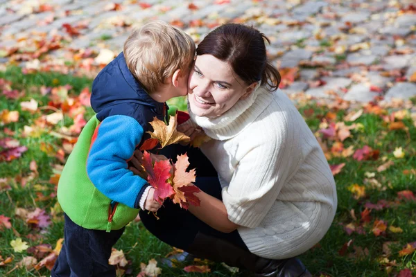 Pequeño niño y madre joven en el parque de otoño —  Fotos de Stock