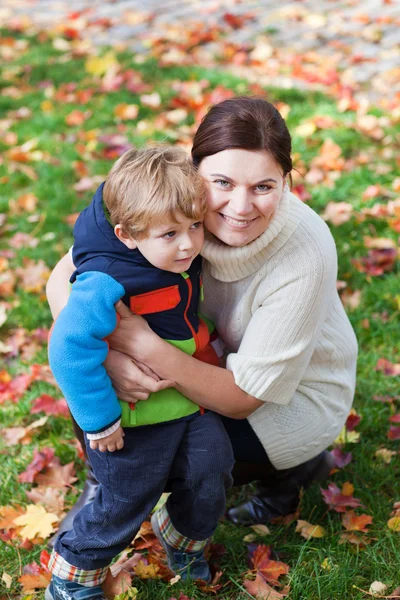 Little toddler boy and young mother in the autumn park — Stock Photo, Image