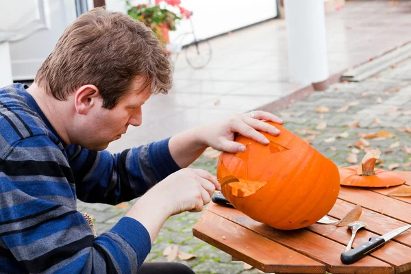 Giovane uomo che fa zucca di Halloween — Foto Stock