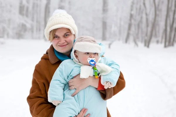 Young woman and little baby boy in winter forest — Stock Photo, Image