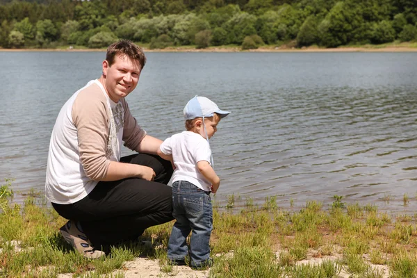 Ung man med småbarn pojke på sjön på sommaren — Stockfoto