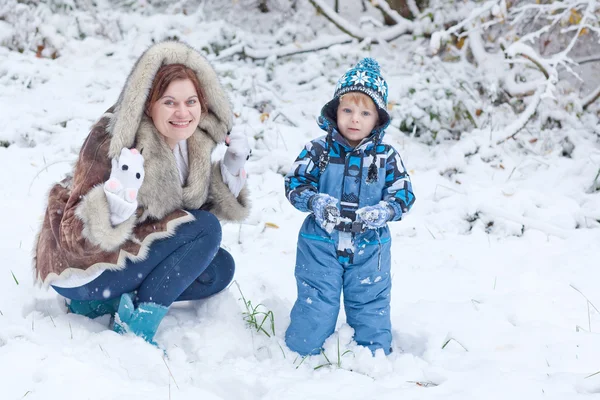 Mother and toddler boy having fun with snow on winter day — Stock Photo, Image