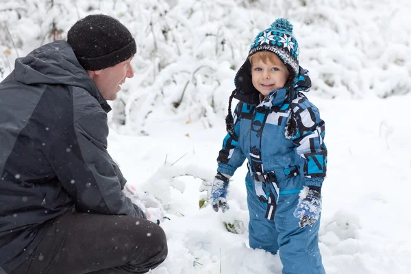 Kar kış gününde eğleniyor baba ve yürümeye başlayan çocuk — Stok fotoğraf