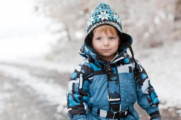 Nuttet lille dreng har det sjovt med sne på vinterdagen - Stock-foto